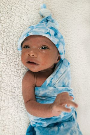 Newborn baby wrapped on soft blanket