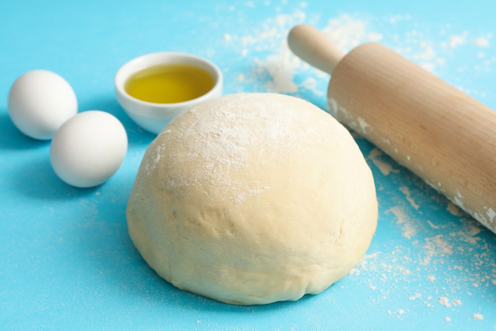 Concept for baking with dough on blue background