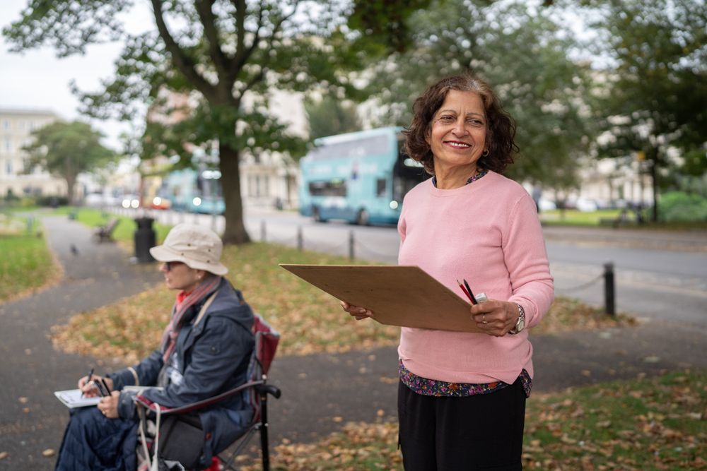 Smiling Indian woman standing with drawing board