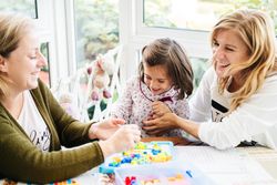 Woman playing board game with daughter and granddaughter