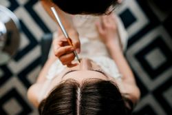 Top view of make-up artist putting make-up for a woman