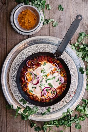Fragrant shakshuka with onion rings in pan