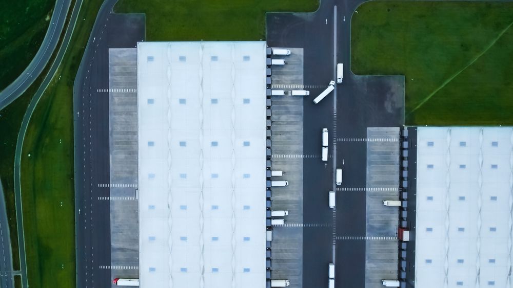 Aerial Shot of Truck with Attached Semi Trailer Leaving Industrial Warehouse