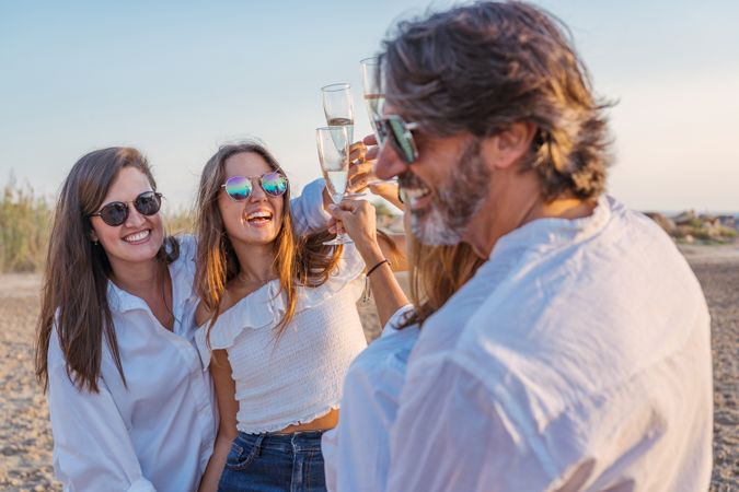 Happy family drinking wine on beach