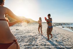 Fun group of women playing along the shore with squirt guns 42Yjy5