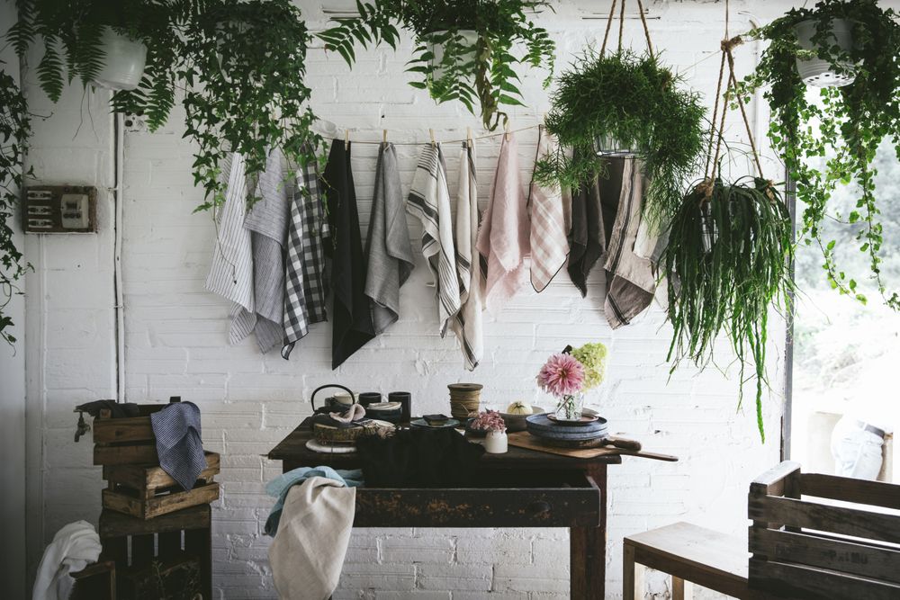Table with flowers in vase on trays near towels hanging on thread