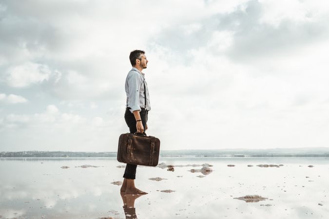 Fancy man with suitcase gazing at seaside