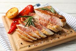 Board with fried steak on wooden background. Grilled food