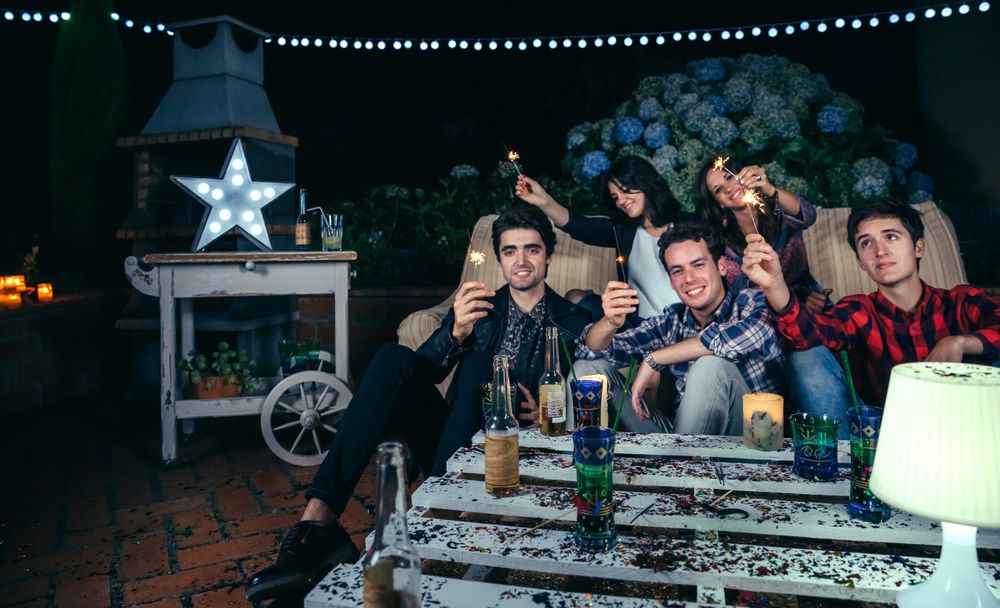 Smiling friends holding sparklers at an outdoor party