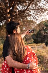 Couple kissing and taking photo outdoors