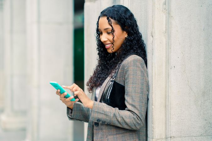 A woman is engaged with her smartphone while enjoying the outdoors in a vibrant environment