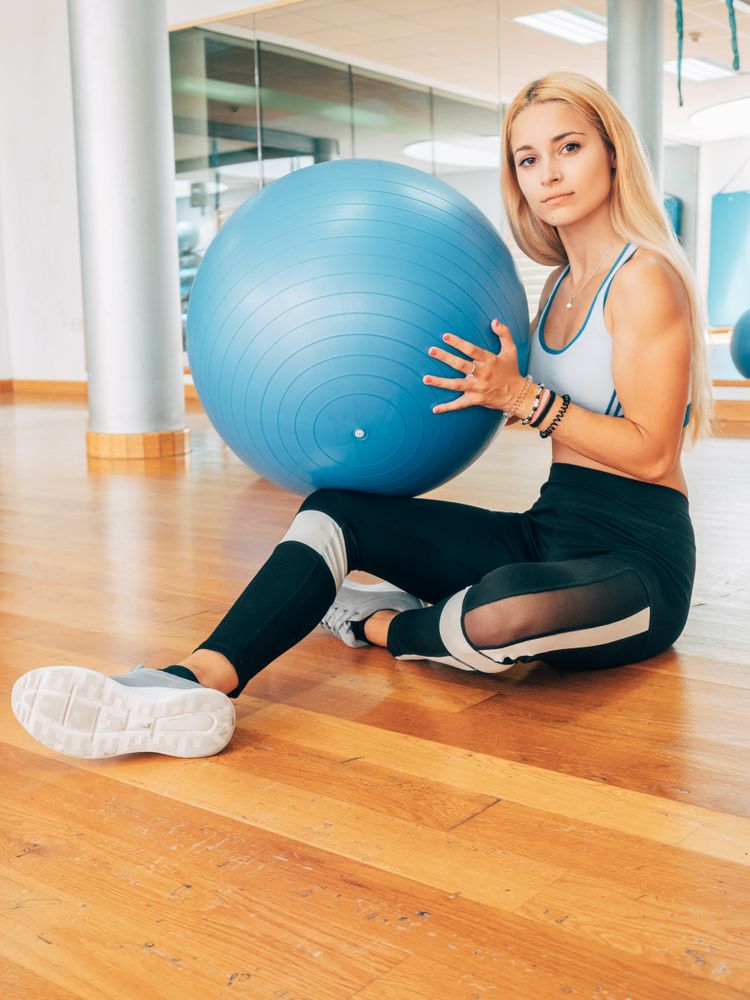 Female athlete with fitness ball on floor