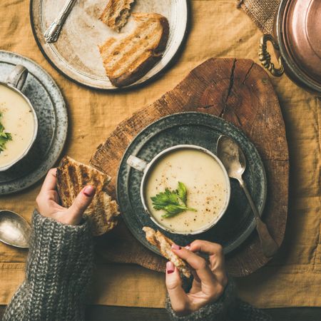 Woman with toast, and celery soup in cup, square crop