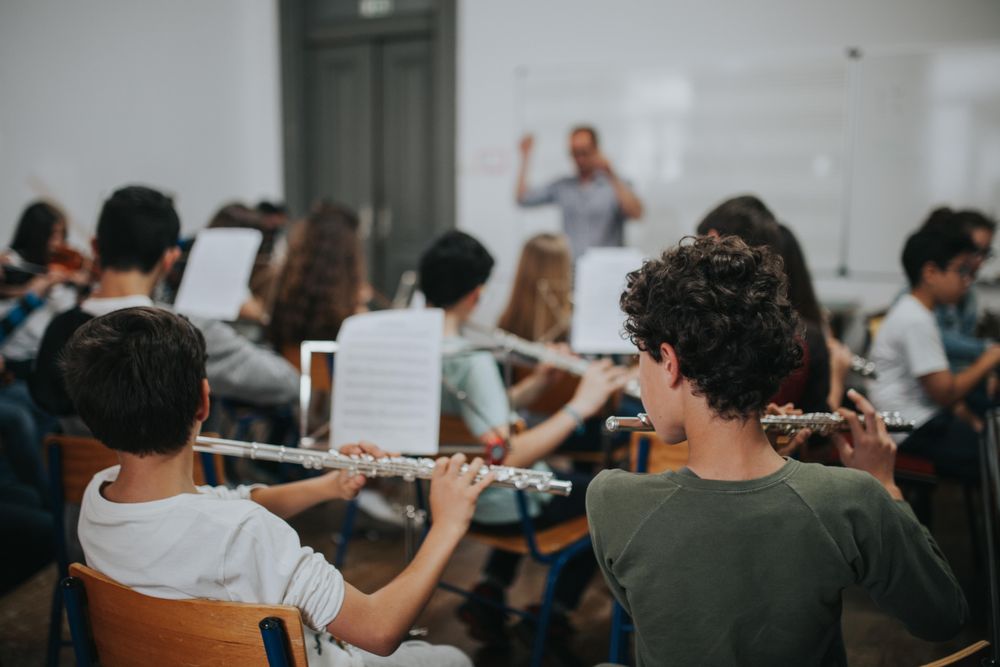 Band class practicing song with instructor in the background