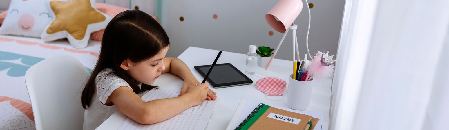 Girl studying at home with mask on table