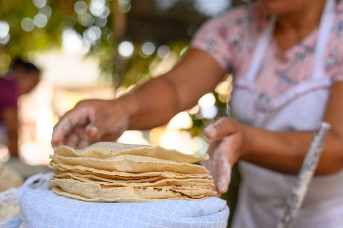 Crop female adjusting fried Mexican flatbreads in countryside