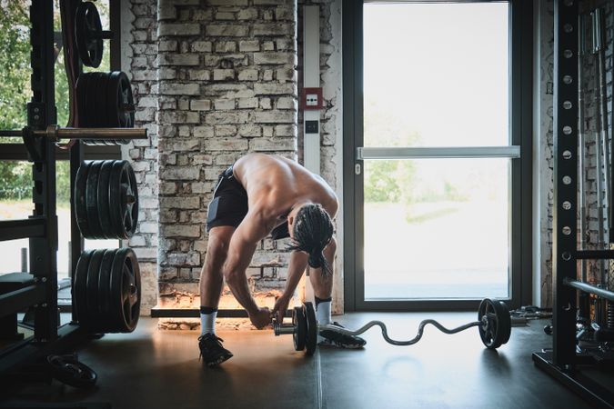 Black man exercising with barbell in gym
