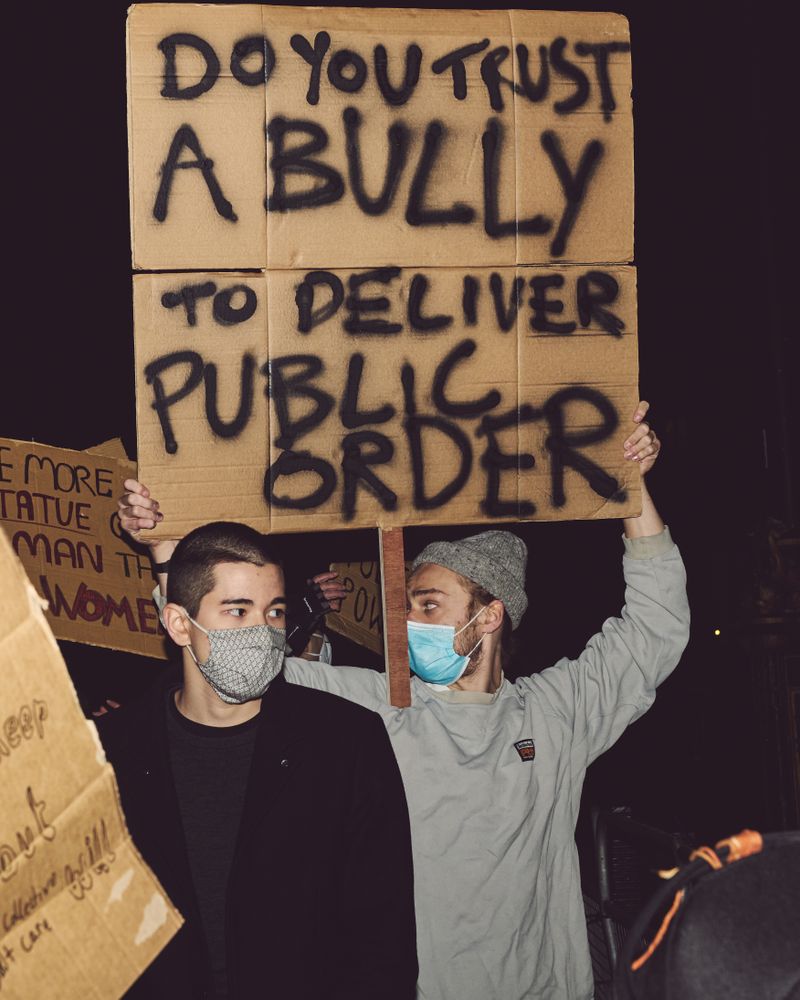 London, England, United Kingdom - March 16, 2021: Two men holding protest signs