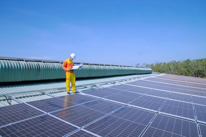 Man with bump cap standing on solar panel