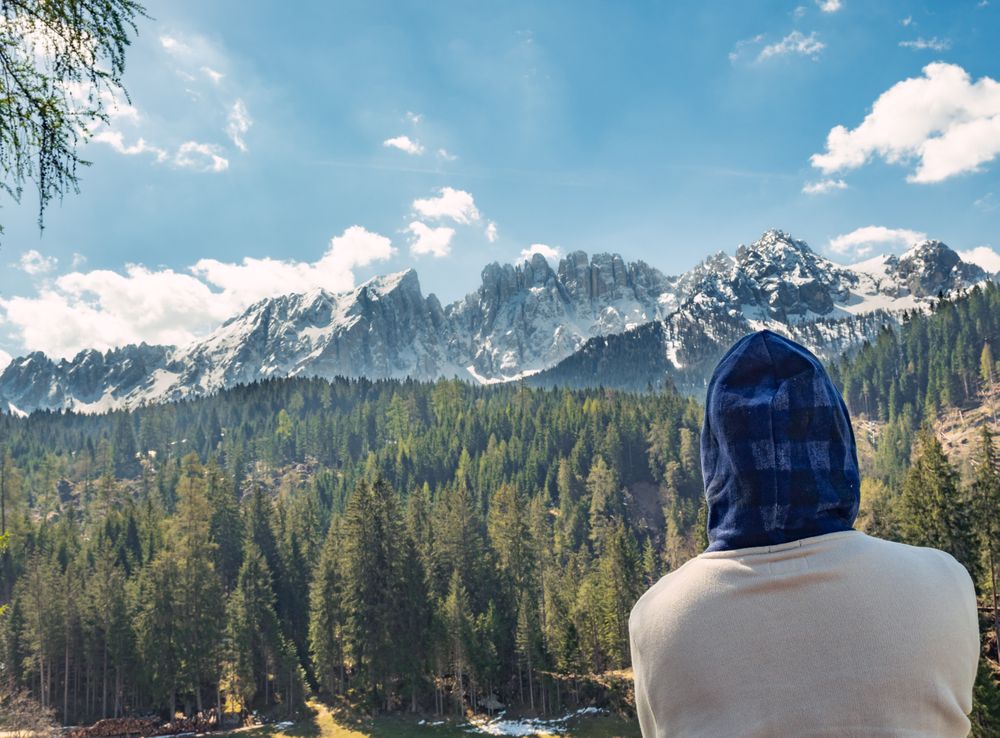 Woman covering head from sun and looking at amazing landscape