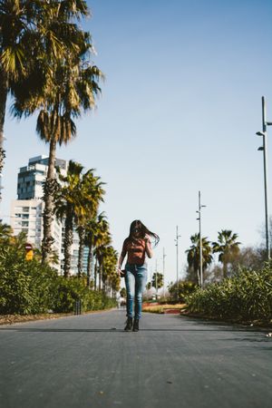 Teen girl walking happily through the streets.