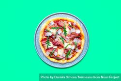 Homemade prosciutto pizza minimalist on a green table 49JKnb