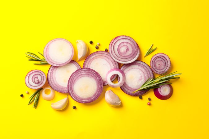 Flat lay composition with red onion rings and spices on color background