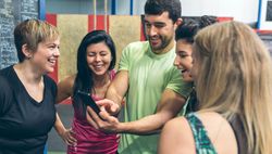 Athletes looking at the mobile of a gym mate