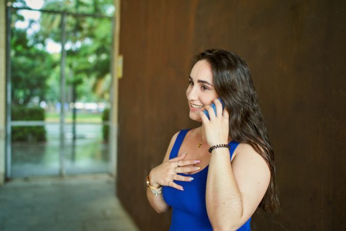 Smiling woman talking on cell phone with a surprised gesture