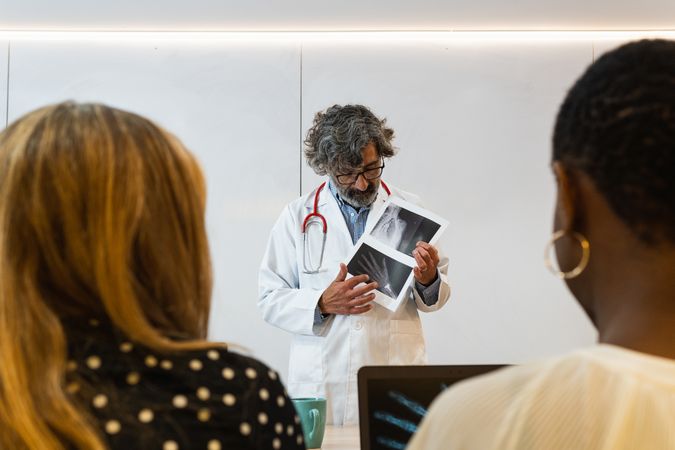 Doctor discussing x ray with colleagues in hospital