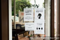Covid safety signs in coffee shop window 5r9jP0
