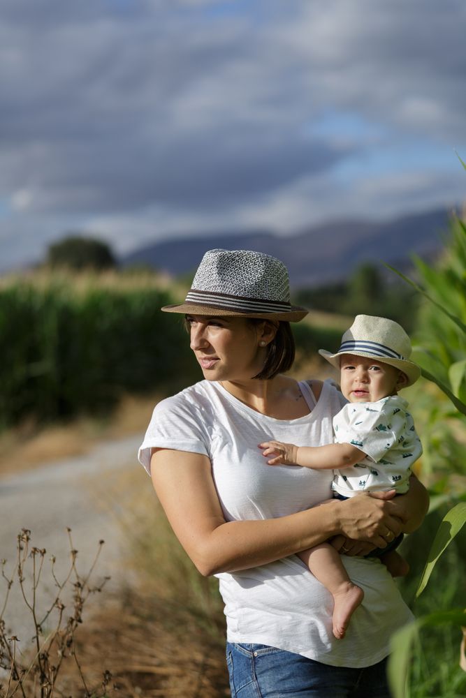 Adorable mother and child on hand enjoying and laughing in field