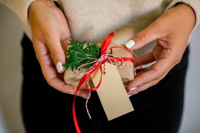 An unrecognizable woman holding Christmas gift in hand