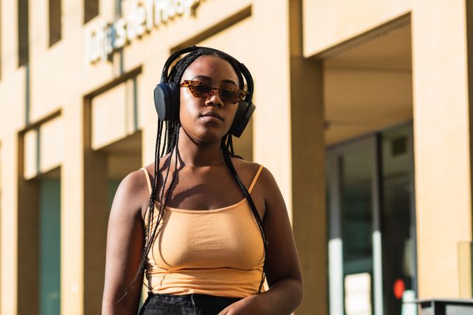 female listening to music outside modern building
