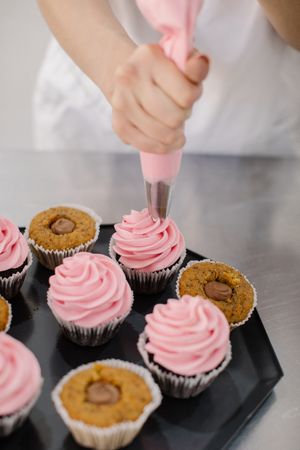 Chef making cupcakes with icing
