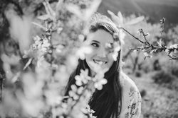 Young happy woman between trees in garden
