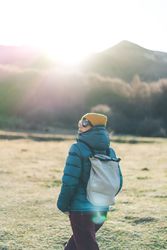 Traveler with backpack walking on autumn field