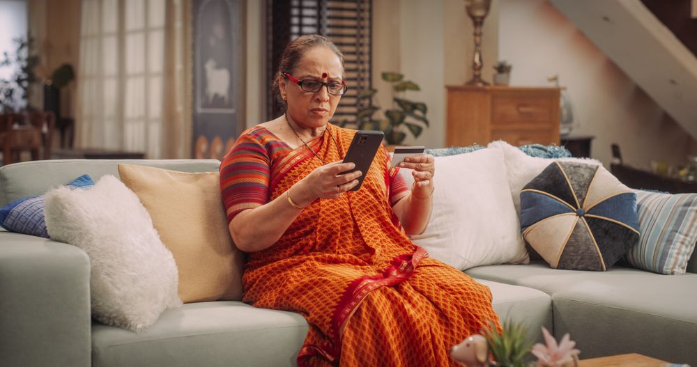 Older Indian Woman Using Smartphone and Credit Card