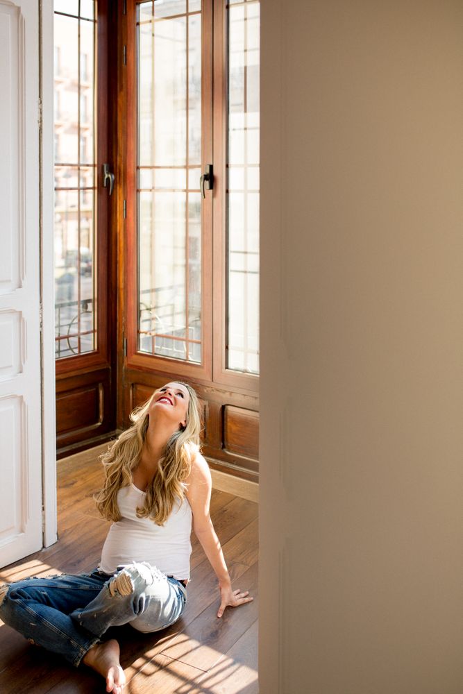 Cheerful pregnant woman relaxing on floor
