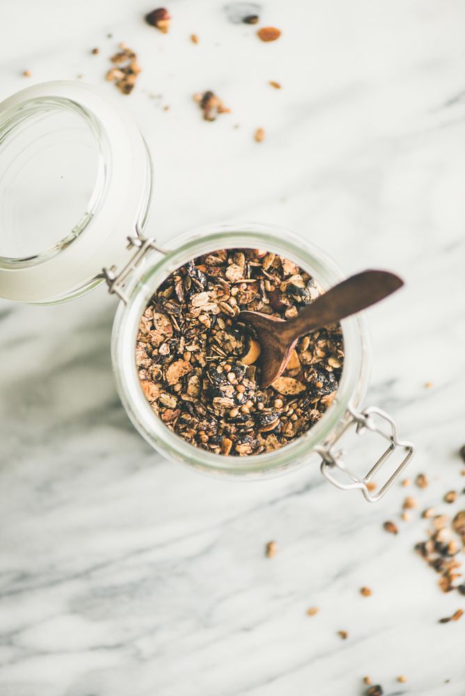Top view glass container of homemade granola, with copy space