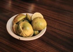 Chopped limed in bowl on wooden table