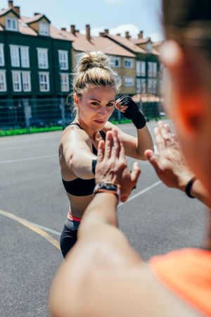 Sportswoman training boxing with her trainer