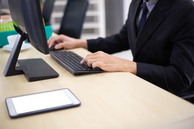 Male employee on computer keyboard in office