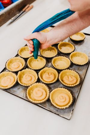 Crop baker squeezing dough on tray