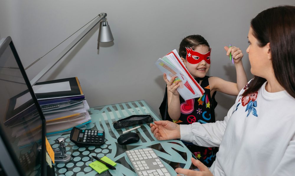 Woman working from home with her daughter interrupting her