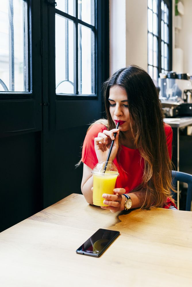 Woman with smoothie in cafe