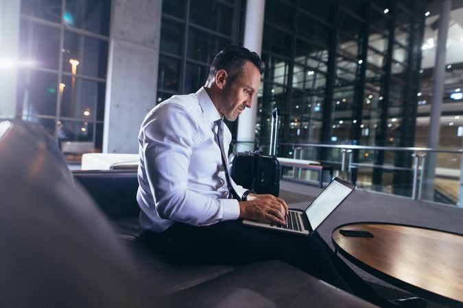 Businessman waiting at the airport using laptop