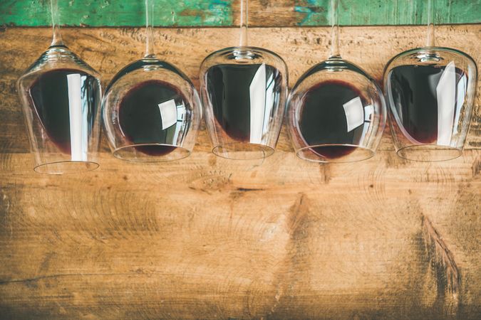 Glasses of red wine glasses laying on wooden background, with copy space