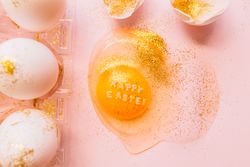 Easter eggs in box and broken egg on table