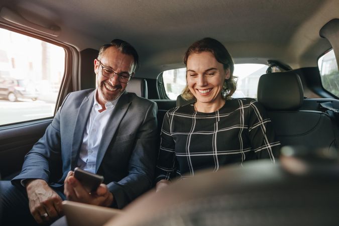 Business people working in backseat of taxi